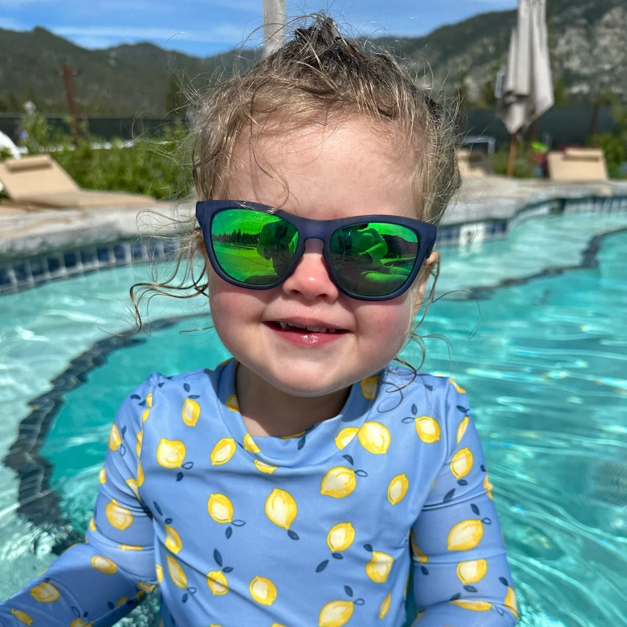 Little girl wearing blue kids polarized sunglasses by sunnies shades