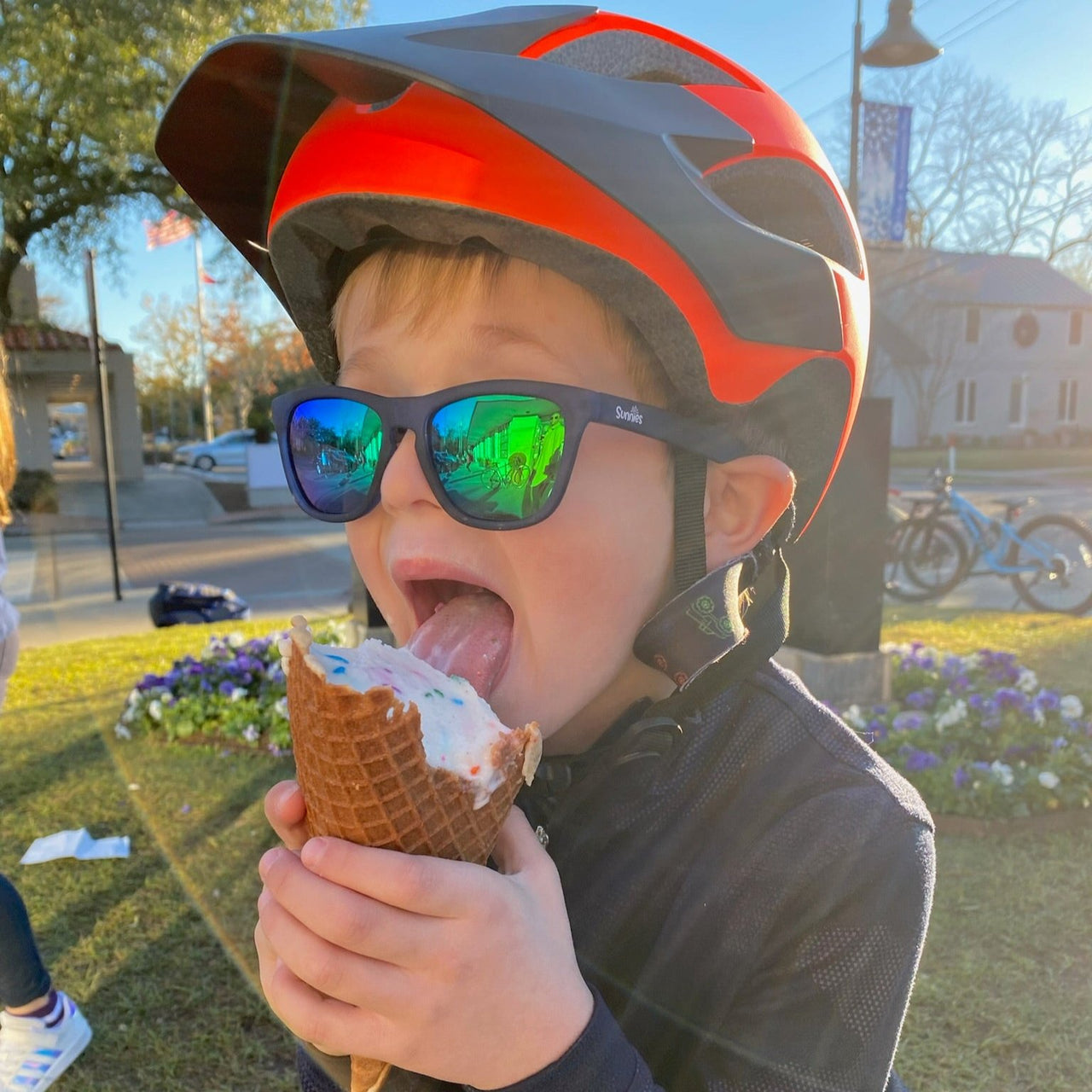 Little boy eating ice cream and wearing blue polarized kids sunglasses by sunnies