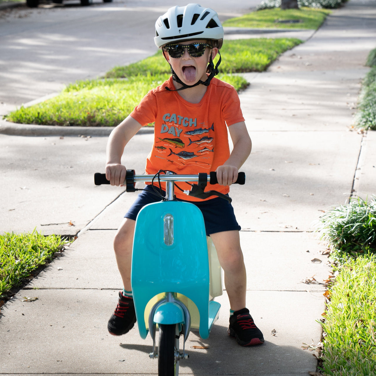 100% Happiness Guaranteed with Sunnies, polarized kids sunglasses as shown by this little boy wearing them while riding a mini scooter.